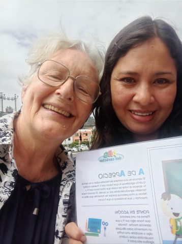 8 Jenny with a thankful mother of 2 receiving her activity book for her children.